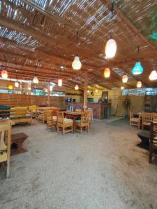 a large room with wooden tables and chairs and lights at Al Deira Dahab Hotel in Dahab +11 photos