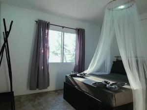 sypialnia z łóżkiem z moskitierą w obiekcie Paradise Sunset Beach w mieście Koh Rong Sanloem