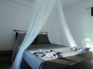 Una cama con dosel y dos toallas. en Paradise Sunset Beach, en Koh Rong Sanloem
