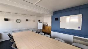 a meeting room with a table and a projection screen at Sweet Home in Belley
