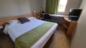 a bedroom with a large bed and a television at Sweet Home in Belley