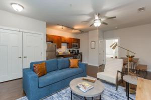 uma sala de estar com um sofá azul e uma mesa em CozySuites MusicRow Alluring 1BR w free parking 43 em Nashville