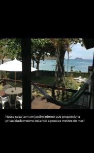 a view of a beach with a hammock and the ocean at Casa fantástica em Búzios- João Fernandes in Búzios