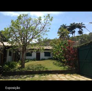 a house with a tree in front of a yard at Casa fantástica em Búzios- João Fernandes in Búzios