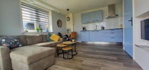 ein Wohnzimmer mit einem Sofa und einer Küche in der Unterkunft Huis over de dijk in De Kwakel