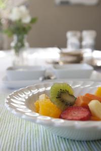 a white plate of fruit on a table at Tancredi B&B in Pietermaritzburg