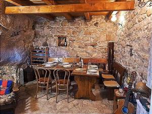 a wooden table in a room with a stone wall at Kuća za odmor Leptirić in Pisak