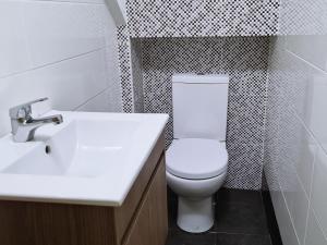 a bathroom with a white toilet and a sink at MR House - Self Check-in in Coimbra