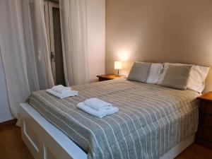 a bedroom with a bed with two towels on it at MR House - Self Check-in in Coimbra