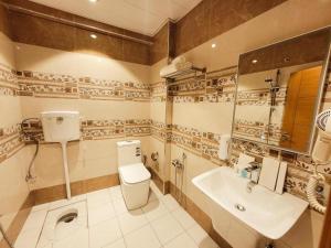 a bathroom with a toilet and a sink at King Hotel Karbala in Karbalāʼ