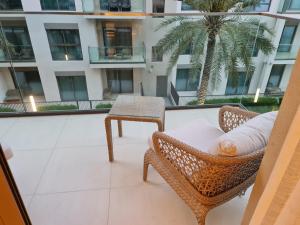 a balcony with chairs and a table and a palm tree at The Address Beach Resort Fujairah in Sharm