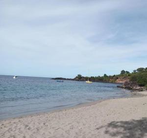 a beach with two boats in the water at Maïya in Bouillante