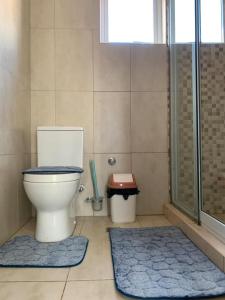 baño con aseo y 2 alfombras azules en The Greens Estate, en Madina