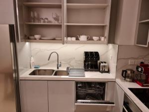 a small kitchen with white cabinets and a sink at The Address Beach Resort Fujairah in Sharm