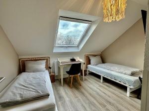 2 Betten in einem Zimmer mit einem Schreibtisch und einem Fenster in der Unterkunft Stilvoll im Zentrum Balken Loft in Bochum