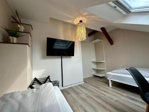 a bedroom with a bed and a tv on the wall at Stilvoll im Zentrum Balken Loft in Bochum