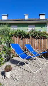 deux chaises de pelouse bleues assises devant une clôture dans l'établissement ECO - Casa Vacanze Arcobaleno, à Arco
