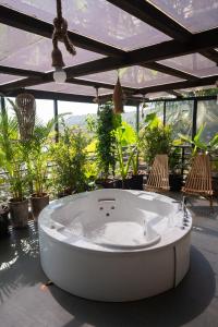 a large white tub sitting on a patio with chairs at ORIGIN BOUTIQUE HOTEL in Goa