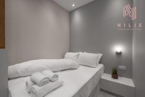 - une chambre blanche avec un lit et des serviettes dans l'établissement Bitola, Nilie Hospitality MGMT, à Thessalonique