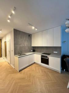 kuchnia z białymi szafkami i drewnianą podłogą w obiekcie Apartment OLD TOWN - Odra - Nice View - 2 Bathrooms we Wrocławiu