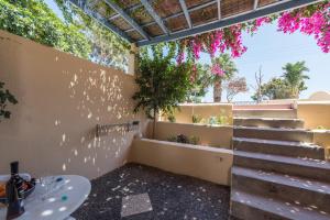 a room with stairs and flowers on the wall at Asterias Mini Coastal Apartments in Perivolos
