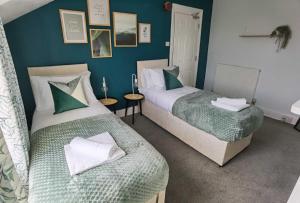 two beds in a room with blue walls at OPP Exeter RRF&T - Cosy 1 bed with parking BIG SAVINGS booking 7 nights or more! in Exeter