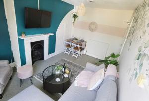 uma sala de estar com um sofá e uma televisão em OPP Exeter RRF&T - Cosy 1 bed with parking BIG SAVINGS booking 7 nights or more! em Exeter