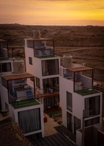 un bâtiment avec balcon et coucher de soleil en arrière-plan dans l'établissement Che Lobitos, à Lobitos