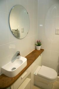 uma casa de banho branca com um lavatório e um espelho em Weasels Way at Tove Valley Cottages em Towcester