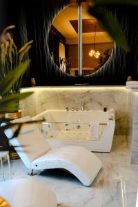 a bathroom with a white tub and a mirror at Hotel Luxor in Lublin