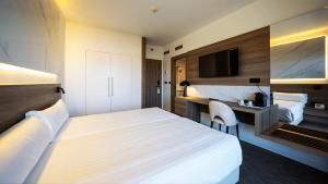 a hotel room with two beds and a desk at Hotel Inffinit Sanxenxo in Sanxenxo