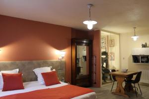 ベリニャにあるOyonnax Bellignat Appart Hotelのベッドルーム1室(赤い枕とテーブル付きのベッド1台付)