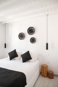Schlafzimmer mit einem Bett mit schwarzen und weißen Kissen in der Unterkunft Anamnisi Mykonos in Mykonos Stadt