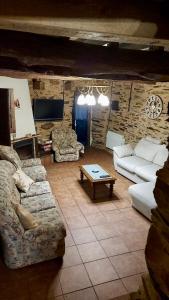 a living room with couches and a table at CASA RURAL BIERZO ENCANTADO in Valle de Finolledo