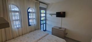 プラヤ・デル・イングレスにあるPlaymar Sun Maspalomasのベッドルーム1室(ベッド2台、テレビ、窓2つ付)