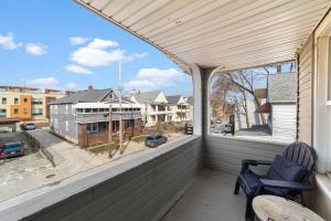 a balcony with two chairs and a view of a street at Pet Friendly 2BR in Little Italy in Cleveland
