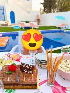 - une table avec un gâteau accompagné d'un sourire dans l'établissement Villa Sarah, à Mezraya