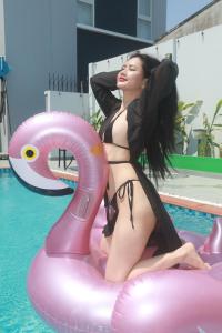 una mujer en bikini sentada en una balsa en una piscina en Villa Amory Mui Ne, en Mui Ne