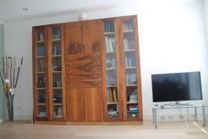 um centro de entretenimento em madeira com estantes de livros e uma televisão em Great Apartment Amsterdam em Amsterdã