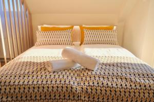 a bed with two pillows on top of it at Trón Apartman in Siklós