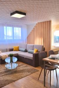 uma sala de estar com um sofá e uma mesa em Trón Apartman em Siklós