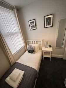 a small bedroom with a bed and a window at Hambledon-Downstairs 2Bed flat in Blythe