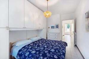 um quarto com uma cama azul e armários brancos em Casa Laura em Arenzano