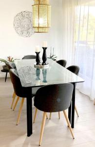 mesa de comedor con sillas negras y encimera de cristal en LAUSANNE PULLY sunny apartment on lakeside street and direct bus to Lausanne train station, en Pully