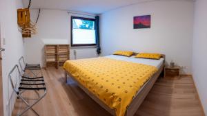 ein Schlafzimmer mit einem Bett mit gelber Bettwäsche und einem Fenster in der Unterkunft Fewo Thielke Fewo 3 Tummelchen in Cochem