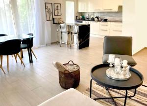 ein Wohnzimmer mit einem Tisch und Stühlen sowie eine Küche in der Unterkunft Lausanne/Pully: appartement moderne et très bien situé in Pully