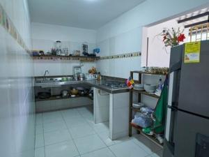 a kitchen with a sink and a refrigerator at La Posada Casa Hostal in San Vicente de Chucurí