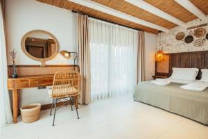 una camera da letto con scrivania, letto e specchio di N Hotels Çeşme a Dalyanköy