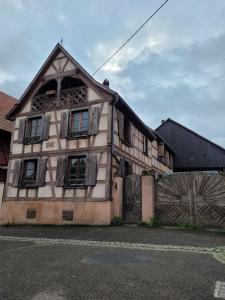 uma casa velha com um portão e uma cerca em Le Grain Noble - Demeure Alsacienne de Caractère em Zellwiller