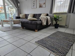 sala de estar con sofá y suelo de baldosa en Rebstock, en Überlingen